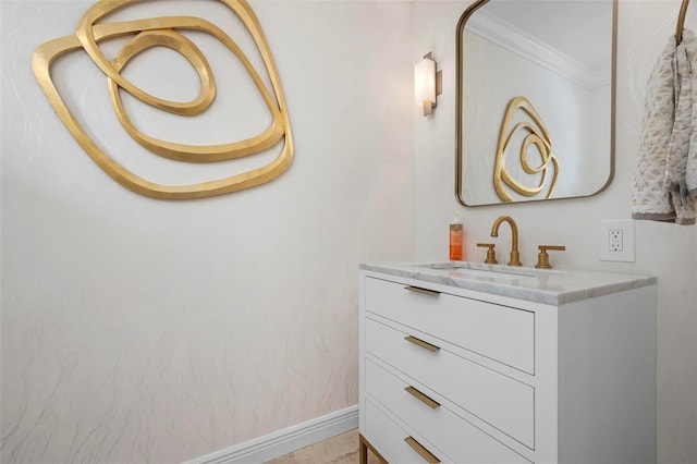 bathroom featuring baseboards, ornamental molding, and vanity