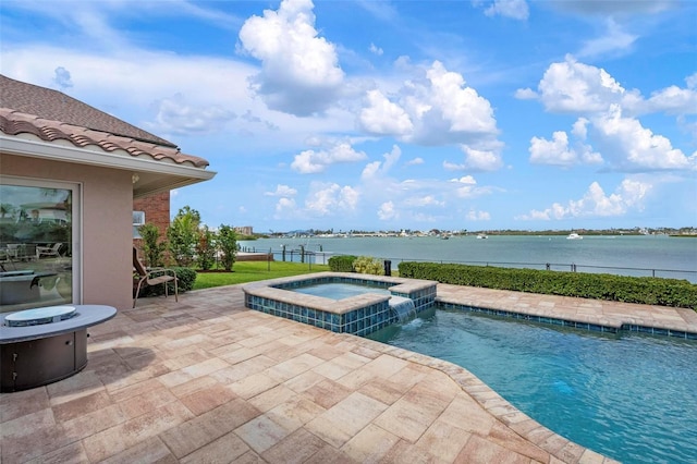 view of swimming pool with a pool with connected hot tub, a patio area, and a water view