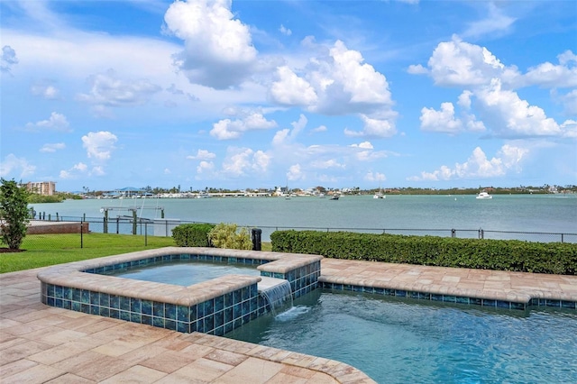 view of swimming pool with a water view, fence, and a pool with connected hot tub