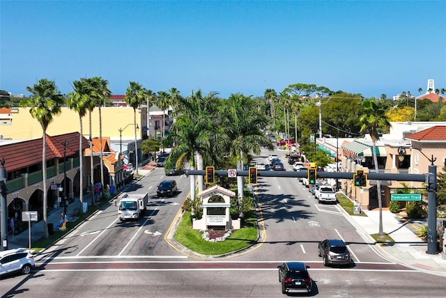 view of street featuring sidewalks, traffic lights, street lights, and curbs