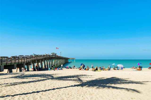 property view of water featuring a view of the beach and a pier