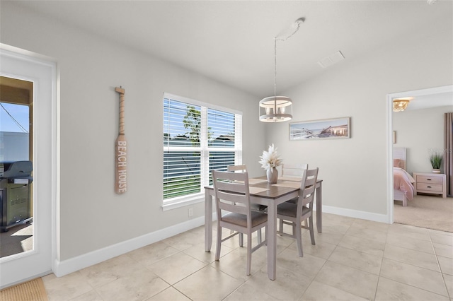 dining room featuring lofted ceiling, visible vents, baseboards, and light tile patterned floors