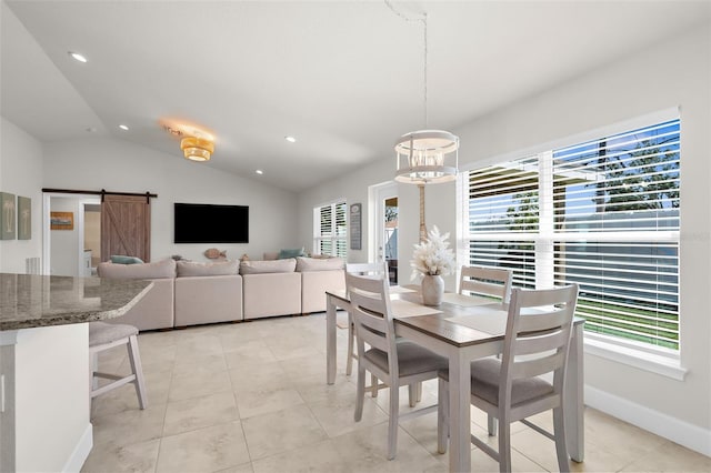 dining space featuring a barn door, vaulted ceiling, a wealth of natural light, and light tile patterned flooring