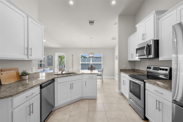 kitchen featuring stainless steel appliances, white cabinetry, a sink, and a peninsula