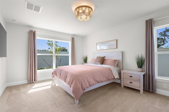 bedroom featuring visible vents, light carpet, and baseboards