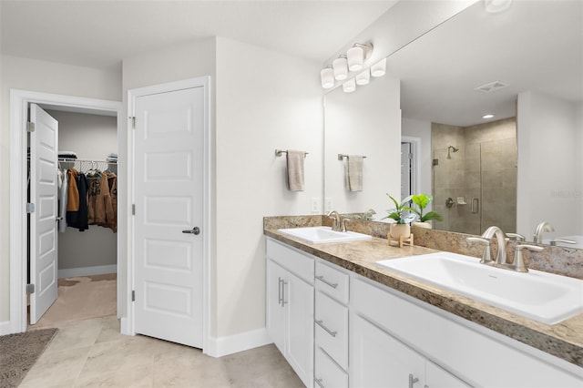 full bath featuring a walk in closet, a sink, visible vents, and a shower stall