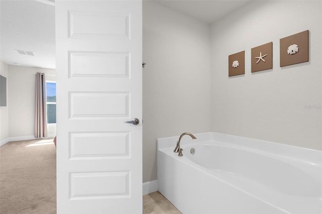 bathroom featuring a garden tub, baseboards, and visible vents