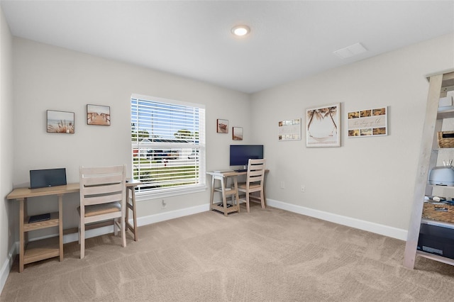 carpeted office space featuring visible vents and baseboards