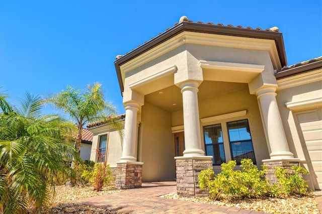 doorway to property with stone siding and stucco siding