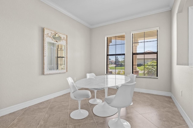 tiled dining area with baseboards and crown molding