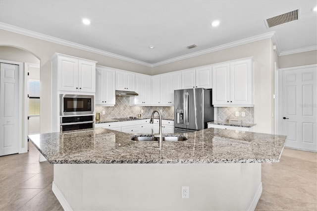 kitchen featuring arched walkways, visible vents, stainless steel appliances, under cabinet range hood, and a sink