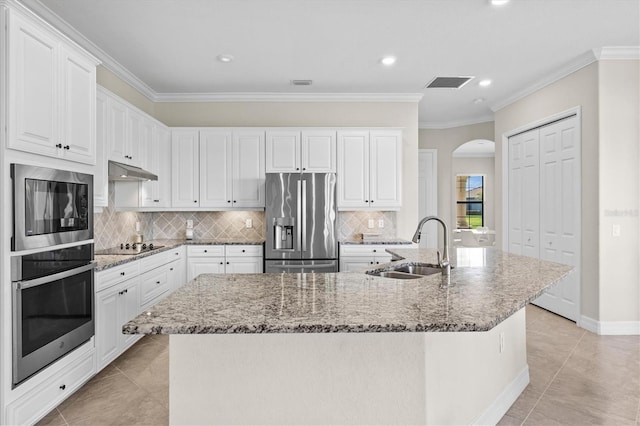 kitchen with light stone counters, visible vents, appliances with stainless steel finishes, a sink, and under cabinet range hood