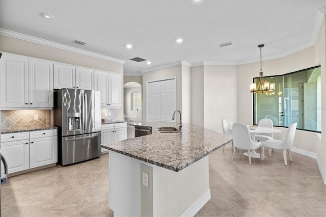 kitchen with arched walkways, visible vents, stainless steel appliances, and a sink