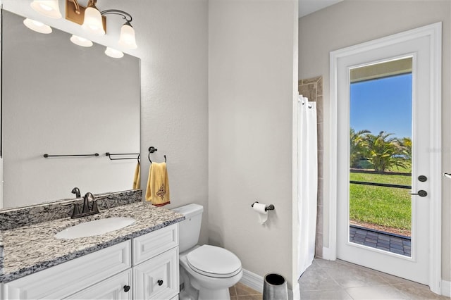 bathroom featuring baseboards, toilet, a shower with curtain, tile patterned flooring, and vanity