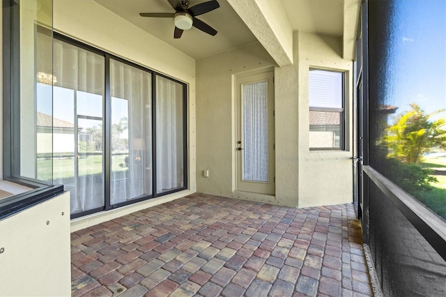 unfurnished sunroom featuring a ceiling fan