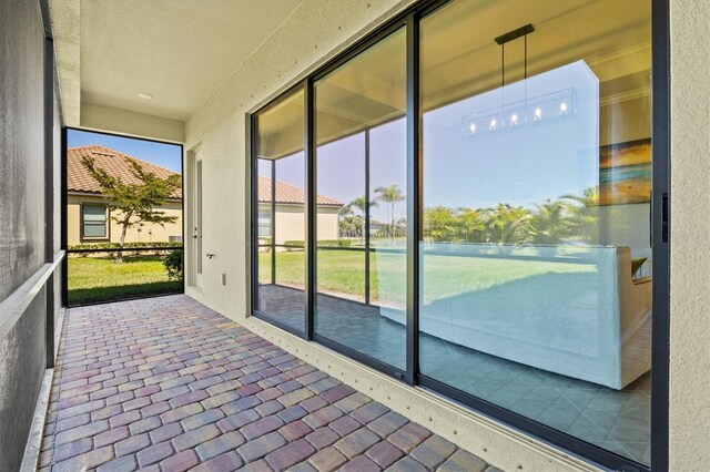 doorway to outside with brick floor and a textured wall