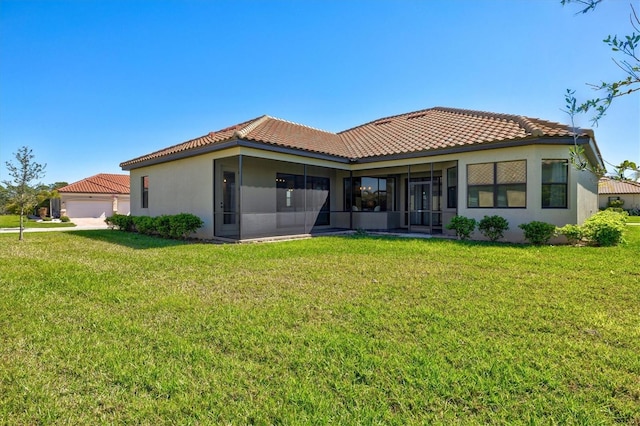 rear view of property with a sunroom, a tile roof, and a yard