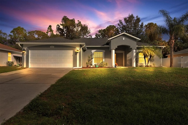 ranch-style home featuring stucco siding, an attached garage, concrete driveway, and a front yard