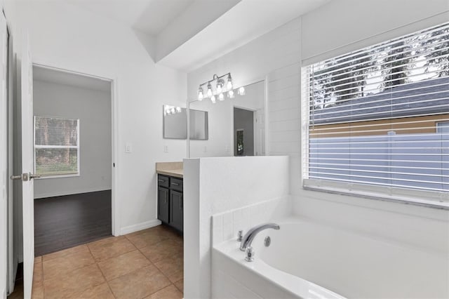 full bath featuring baseboards, a bath, vanity, and tile patterned flooring