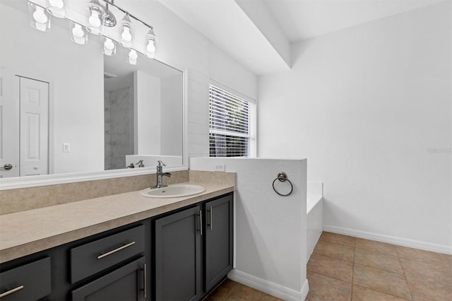 bathroom with vanity, a garden tub, baseboards, and tile patterned flooring