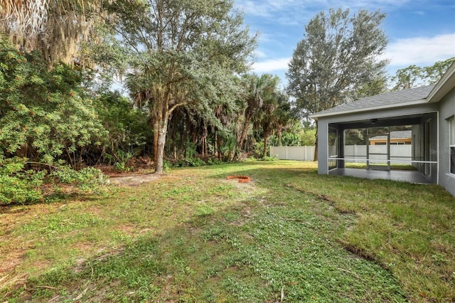 view of yard with fence and a sunroom