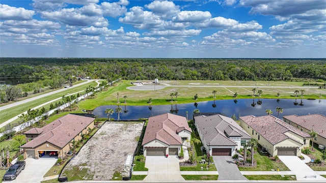 bird's eye view featuring a water view, a residential view, and a wooded view