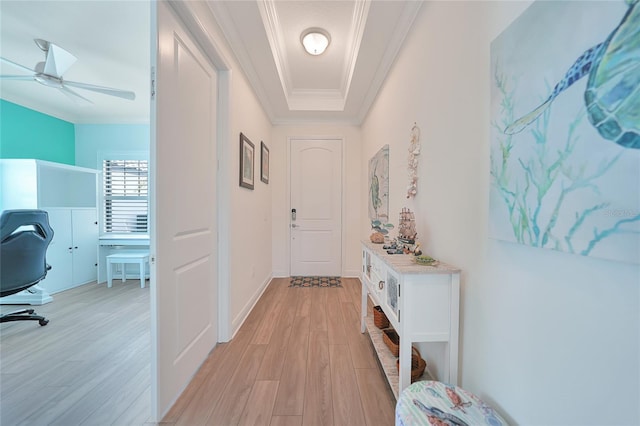 hall with baseboards, light wood finished floors, and crown molding