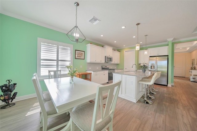 dining space with light wood finished floors, visible vents, crown molding, and recessed lighting