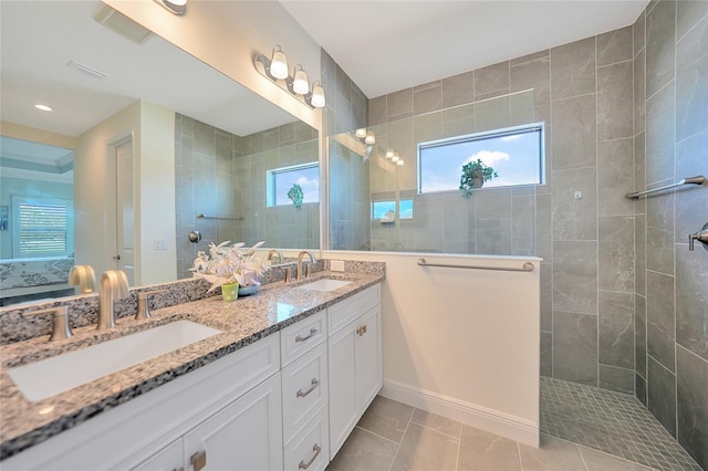 ensuite bathroom with double vanity, walk in shower, a sink, and ensuite bathroom