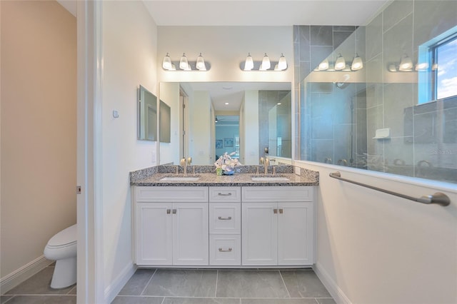 bathroom featuring double vanity, a sink, toilet, and walk in shower