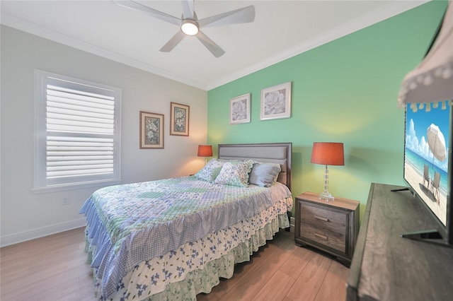 bedroom featuring a ceiling fan, baseboards, ornamental molding, and wood finished floors