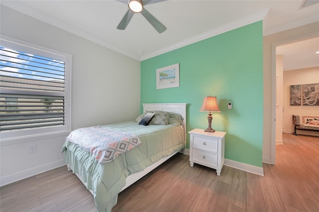 bedroom with ornamental molding, wood finished floors, visible vents, and baseboards