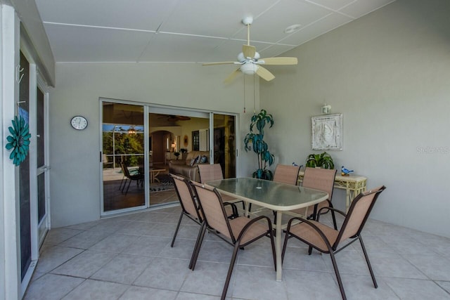 dining area with light tile patterned flooring, arched walkways, lofted ceiling, and a ceiling fan