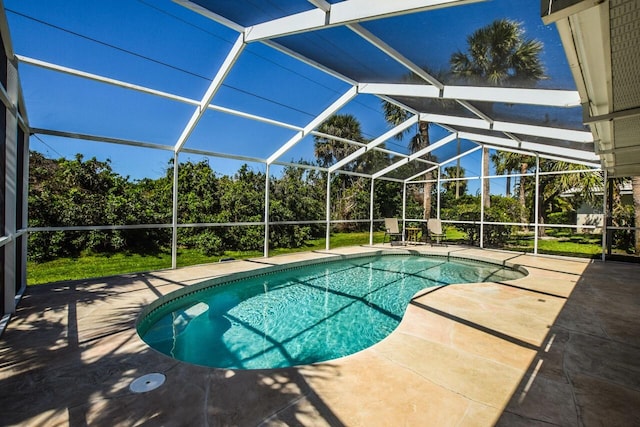 outdoor pool featuring glass enclosure and a patio