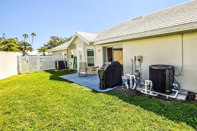 back of property featuring a patio area, a lawn, cooling unit, and fence