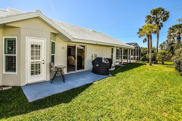 back of property featuring a patio, a lanai, a lawn, and stucco siding