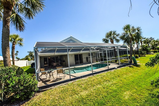 rear view of property with an outdoor pool, a yard, a lanai, and a patio area