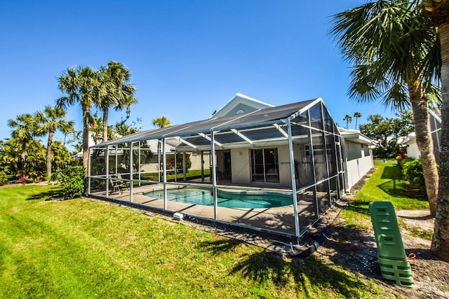 outdoor pool with glass enclosure, a patio area, and a lawn