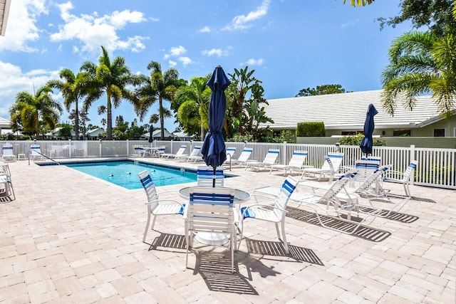 pool with a patio and fence