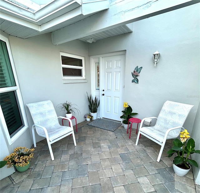 doorway to property with a patio and stucco siding