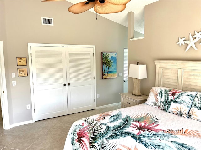 bedroom featuring visible vents, lofted ceiling, light tile patterned floors, a closet, and a ceiling fan