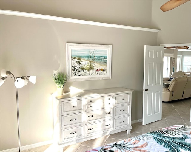 bedroom with light tile patterned floors, crown molding, and baseboards