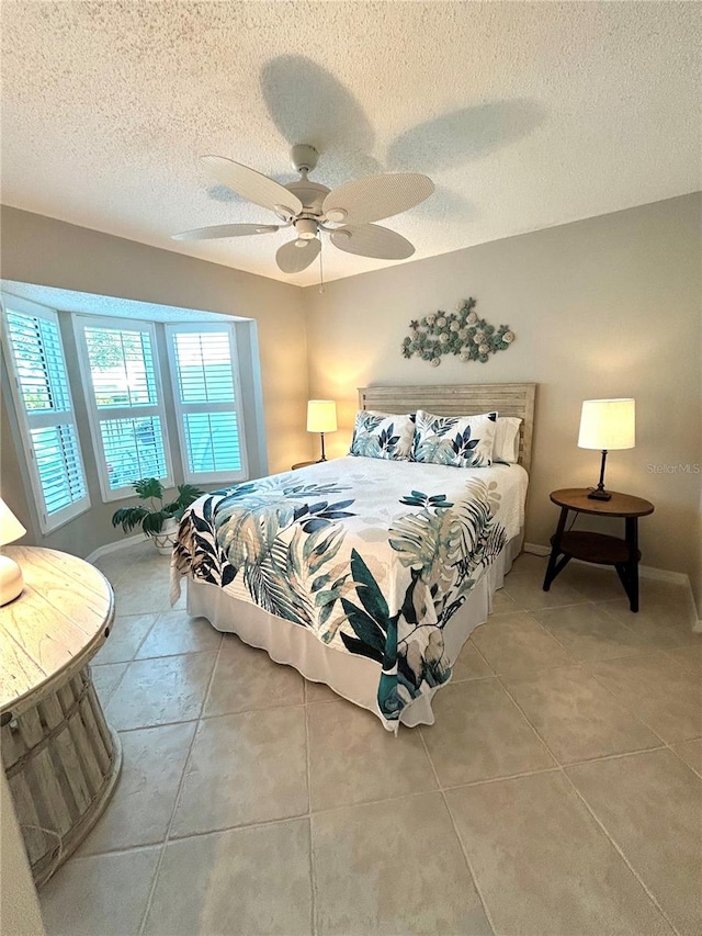 bedroom with a textured ceiling, baseboards, and ceiling fan