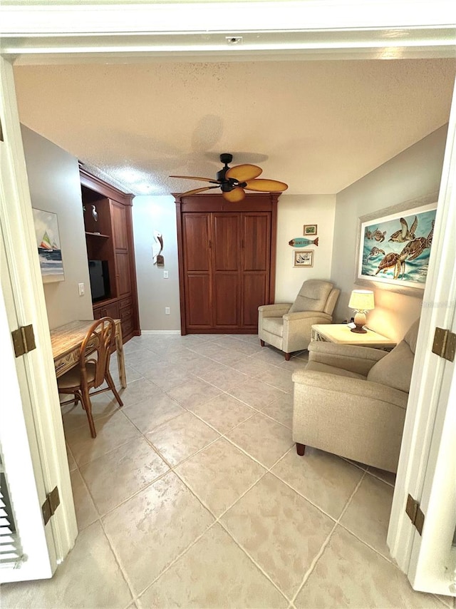 living room with a textured ceiling, light tile patterned floors, and ceiling fan