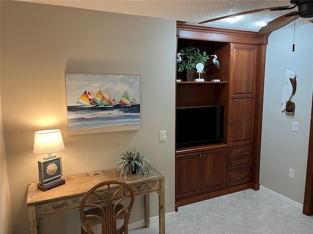 office with light tile patterned floors, baseboards, a textured ceiling, and ceiling fan