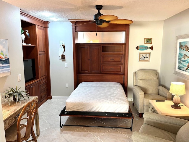 bedroom featuring ceiling fan, baseboards, a textured ceiling, and light tile patterned flooring