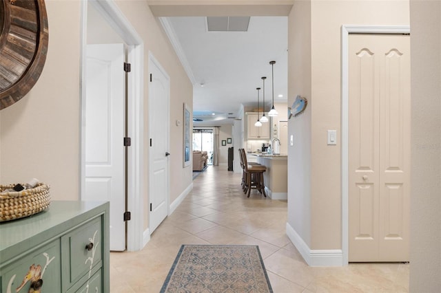 corridor featuring light tile patterned floors, baseboards, visible vents, ornamental molding, and recessed lighting