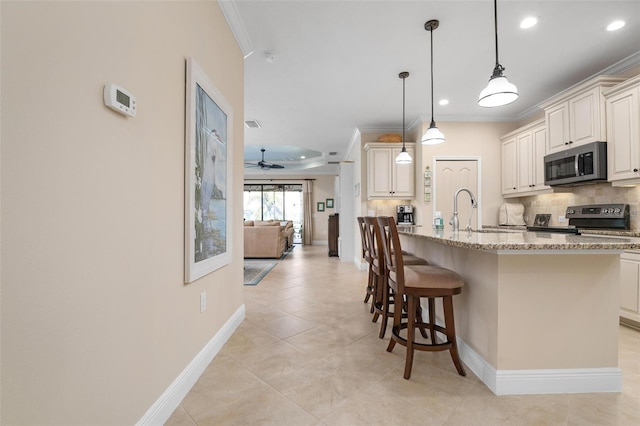 kitchen with tasteful backsplash, light stone countertops, stainless steel appliances, crown molding, and a sink