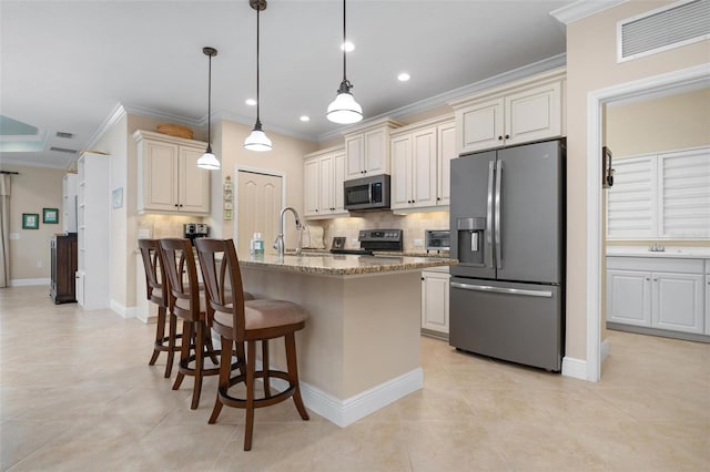 kitchen featuring light stone counters, visible vents, ornamental molding, appliances with stainless steel finishes, and decorative backsplash