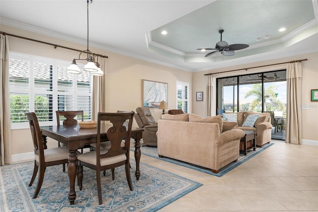 dining room with a healthy amount of sunlight, a tray ceiling, and ornamental molding